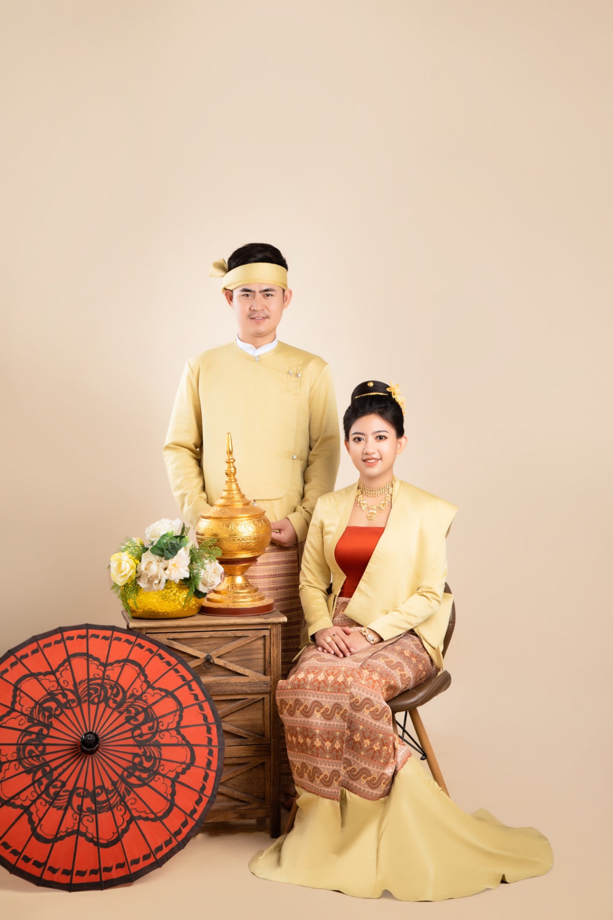 Traditional Myanmar couple portrait with parasol and floral arrangement